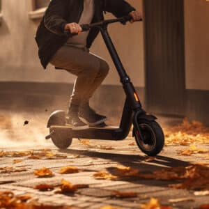 a person riding an electric scooter on a sidewalk through leaves