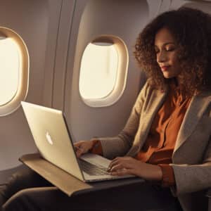Woman working on her laptop while on the airplane | Lithium Batteries in Air Travel