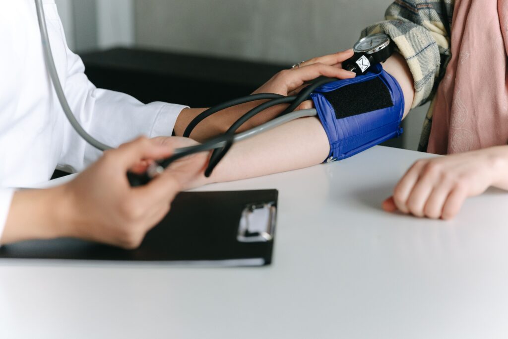Healthcare professional checking a patient's blood pressure during a routine medical examination