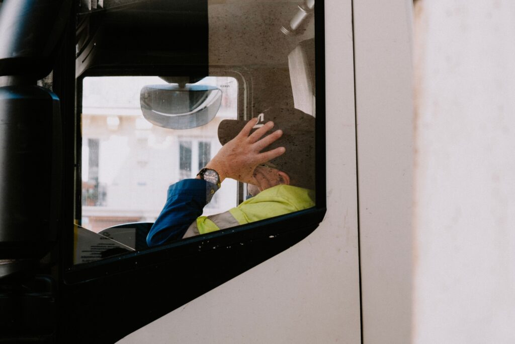 A truck driver rests inside the cab