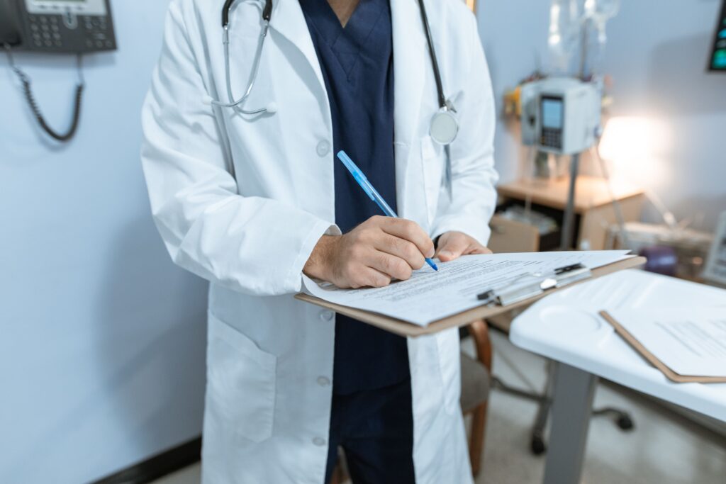 A doctor documents patient information on a medical chart