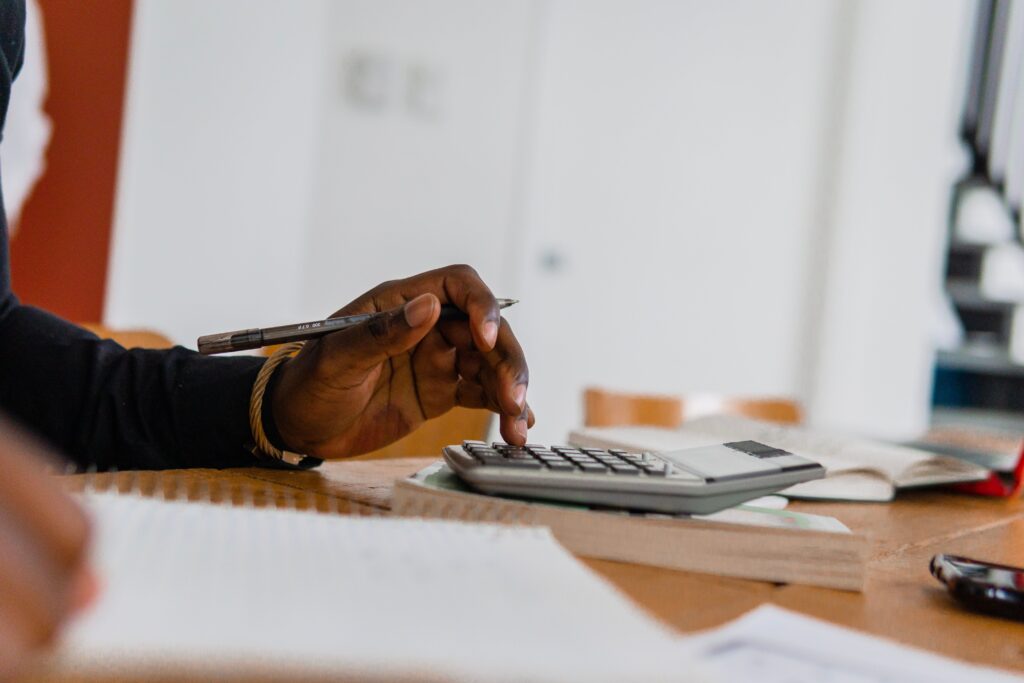 Person using a calculator while reviewing financial documents