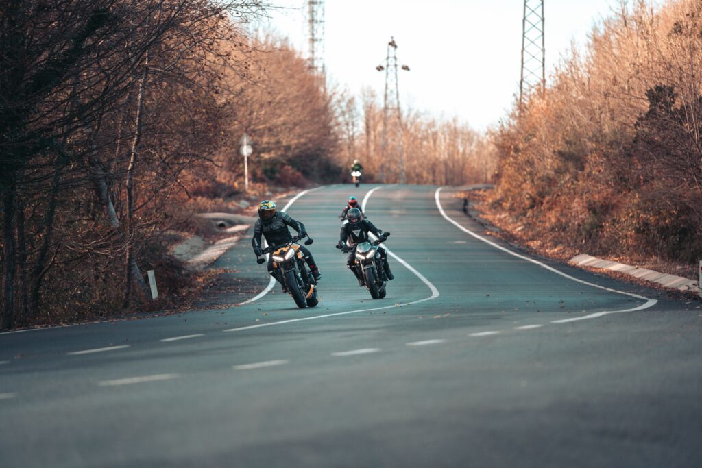 Motorcyclists riding along a winding scenic road, highlighting the freedom of motorcycle travel and the importance of road safety.