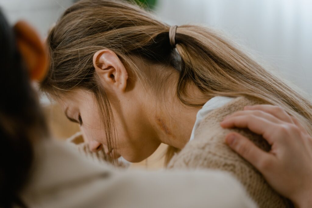A forlorn woman being comforted by another person