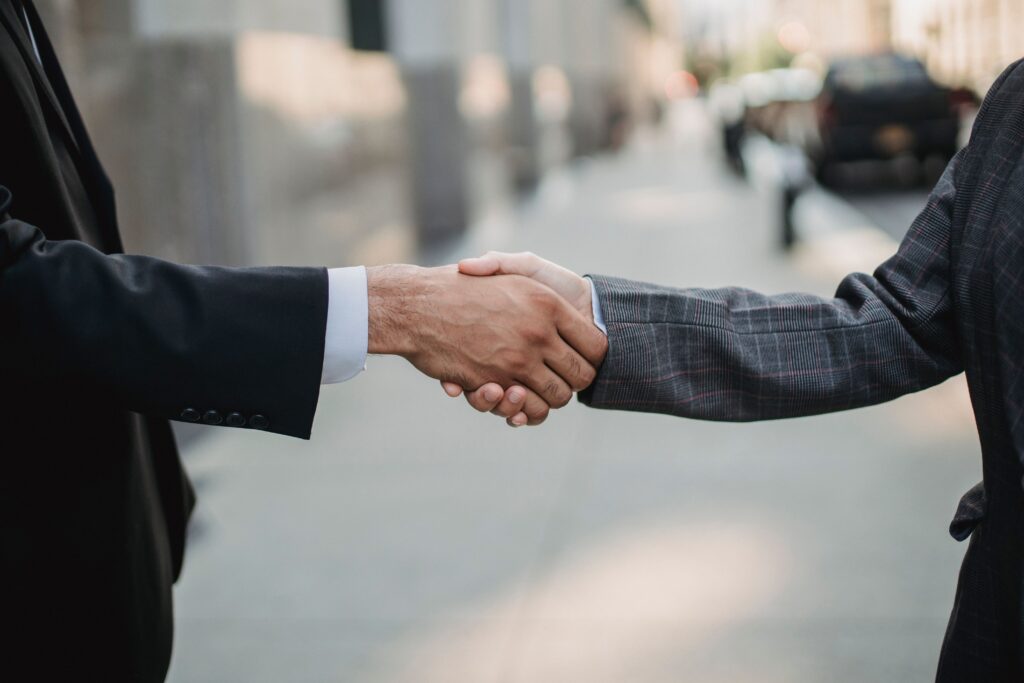 Two business professionals shaking hands, illustrating an agreement or successful settlement negotiation.