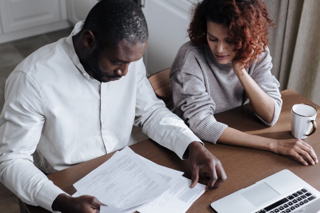 A couple sitting together at a desk while reviewing documents