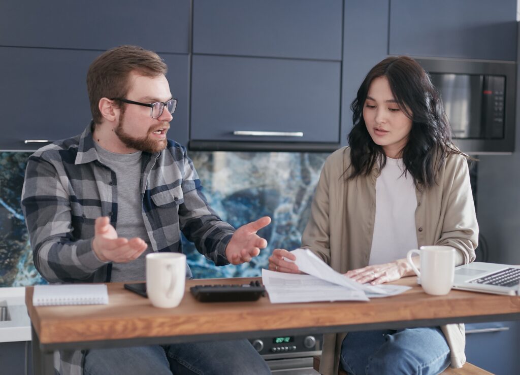 An upset man speaking with a woman holding a document
