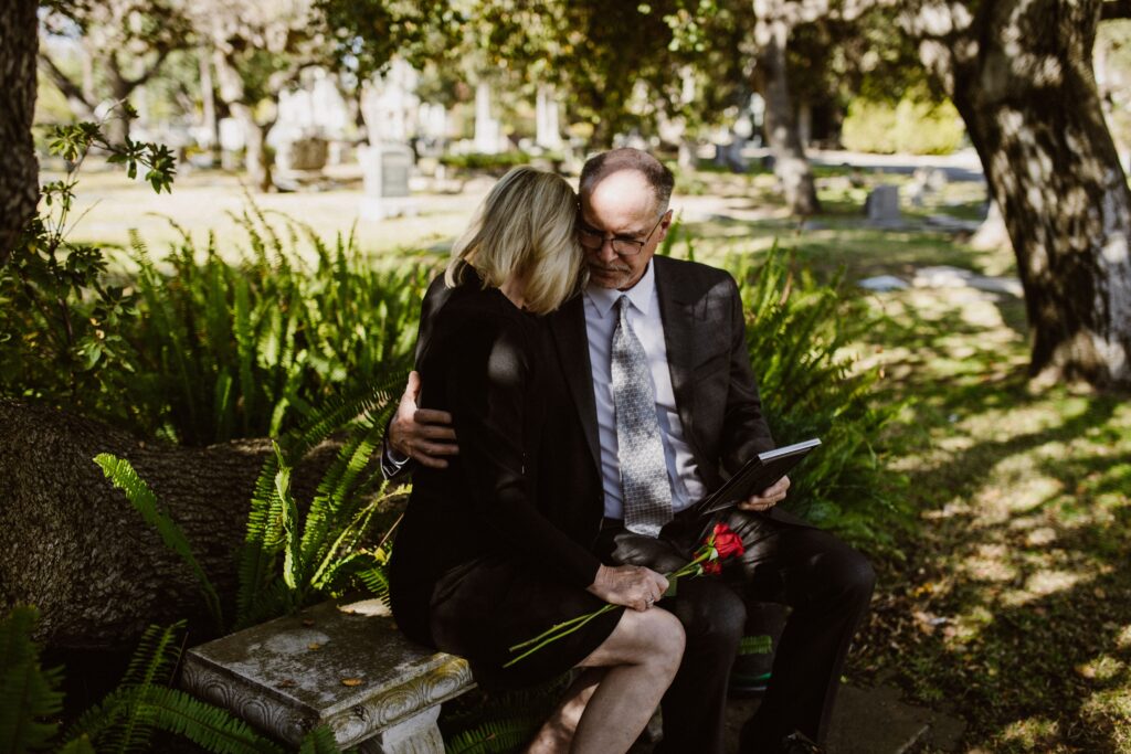 A grieving couple sitting together on a bench
